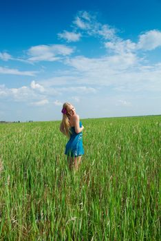 happy woman on green grass on background of the town buildings