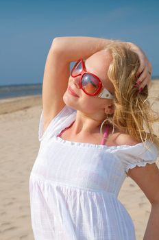 Young woman in summer dress standing on sand