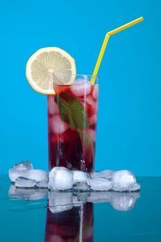 cocktail  with cherry closeup on blue background.