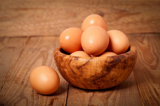 fresh brown eggs on wooden background
