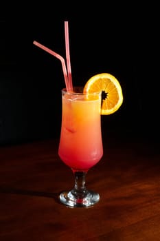 orange juice on a cocktail glass with a slice of orange and grenadine liquor