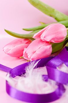 festive traditional easter egg decoration ribbon and tulips on pink background