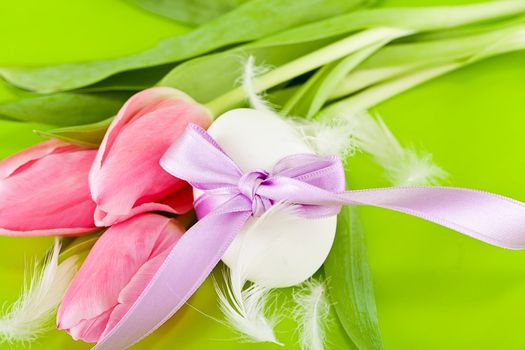 traditional easter egg decoration with tulips and ribbon green background 