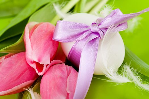 traditional easter egg decoration with tulips and ribbon green background 