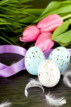 traditional easter egg decoration with tulips and ribbo and feather