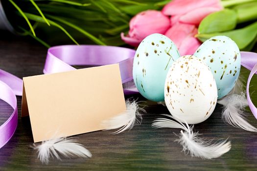 traditional easter egg decoration with tulips and ribbo and feather