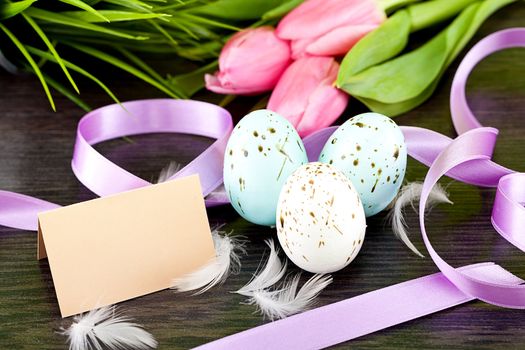traditional easter egg decoration with tulips and ribbo and feather