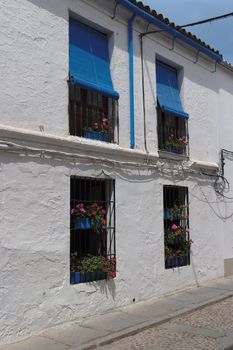 Plastered wall of two-storied Mediterranean house with four windows