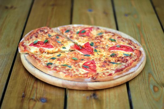 fresh pizza margarita on a wooden plate selective focus