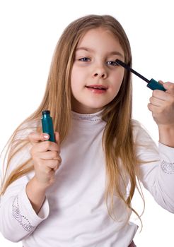 little girl paints the eyelashes mascara. Isolated on white background