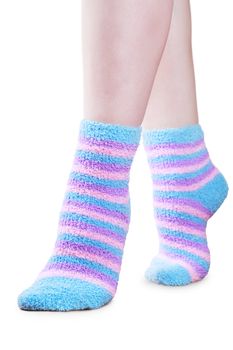 Woman legs in fluffy colorful striped socks ovwe white background