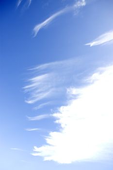 white fluffy clouds and trails against lovely blue sky