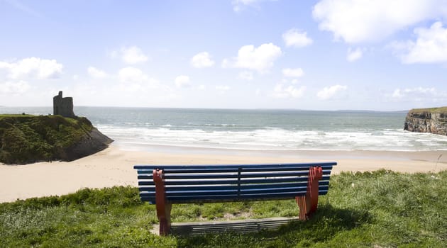 Beautiful view over the Ballybunion castle beach and cliffs in Ireland from a wooden bench