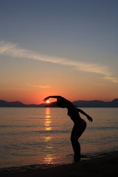 silhouette of a dancer in a beautiful beach at the sunset