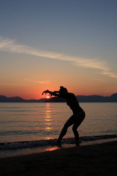 silhouette of a dancer in a beautiful beach at the sunset