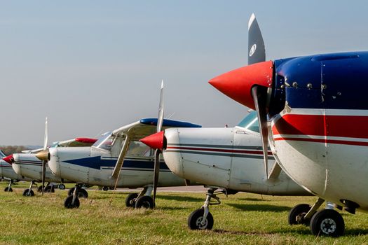 Cessna 152s Tied Down and Parked at Private Airfield against Blue Sky with Copy Space