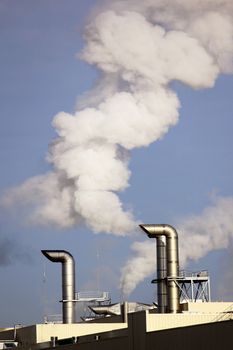 Polluting smoke leaving the chimney of a factory for a productive industry