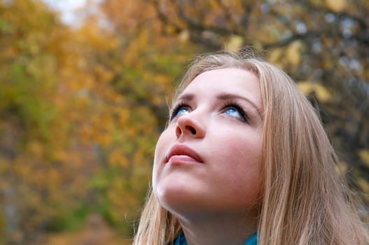 Young pretty blonde woman in the autumn park