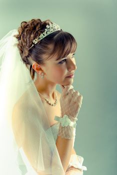 Beauty young bride dressed in elegance white wedding dress  gray studio background
