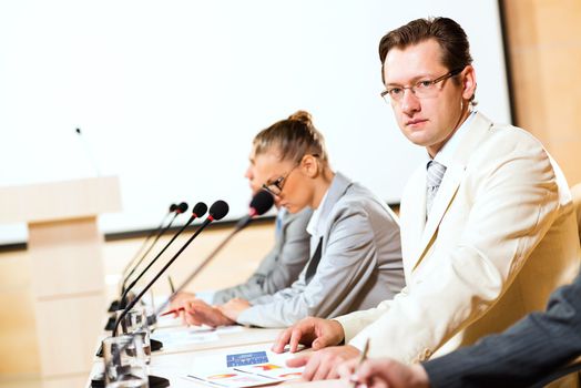 businessmen communicate at the conference, man looking at the camera