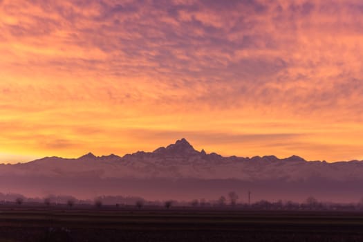 The silhouette of Monviso Vs the red sky