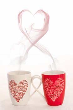 2 coffee cups with herats creating smoke in the shape of a heart on a white background