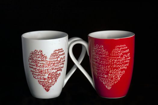 2 coffee cups with hearts on a black background