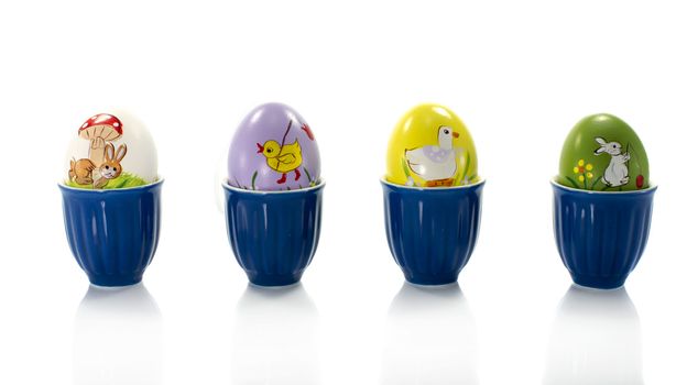 painted easter eggs in blue cups