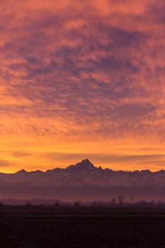 The silhouette of Monviso Vs the red sky