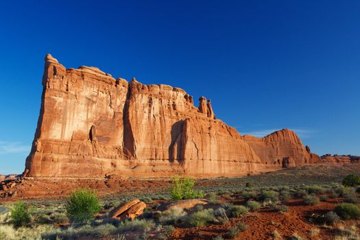 Courthouse Towers Ridge in Arches National Park with dramatic Blue Sky from distance