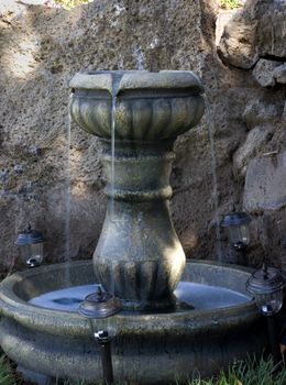 A vertical shot of a a small water feature/garden fountain.