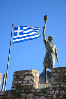 old statue and the greek flag in naypaktos greece