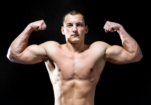 Handsome muscular man isolated on black background