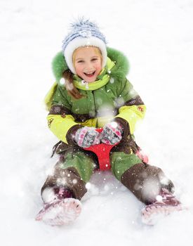 Happy child on sledge in winter