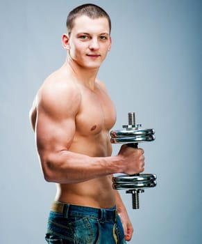 Handsome muscular man use his dumbbell to exercise; flexing bicep meuscle