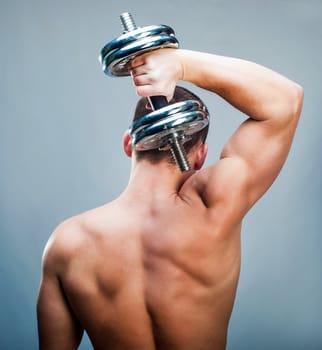 back attractive muscular man with dumbbells
