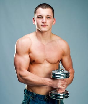 Handsome muscular man use his dumbbell to exercise
