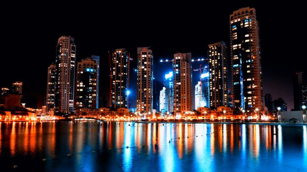 Colorful night view of city of Dubai with modern downtown buildings