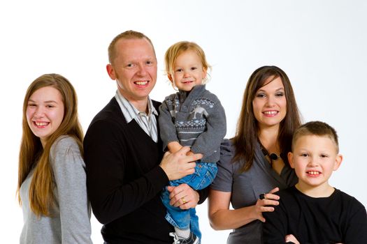 A family of five people on a white isolated background in the studio.
