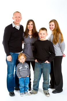 A family of five people on a white isolated background in the studio.