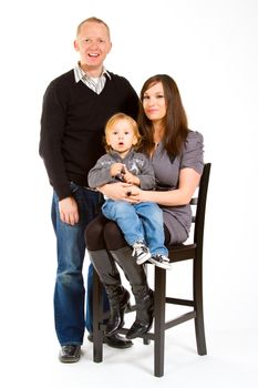 A small family of three portrait in a studio with a white background.
