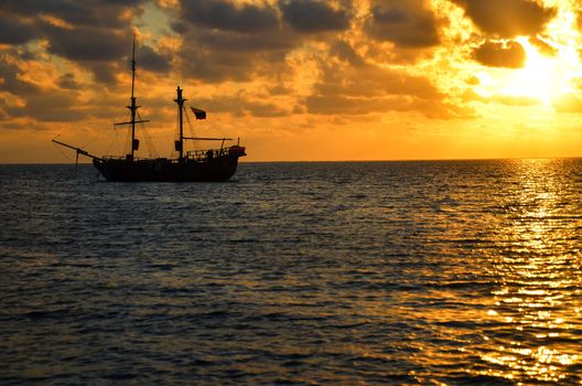 Orange sunrise with pirate ship on Caribbean Sea in San Andres, Colombia
