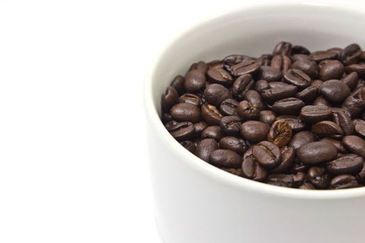 A cup and coffee beans on white background