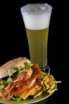Big Tasty Burger  with Bacon, Cheese, Lettuce, French Fries and Beer Glass isolated on black background