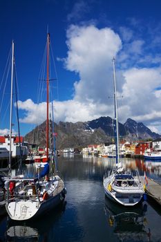 Yacht in picturesque harbor of Henningsvaer on Lofoten islands in Norway