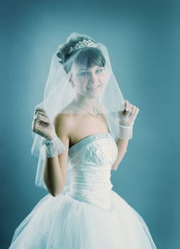 Beauty young bride dressed in elegance white wedding dress  gray studio background 