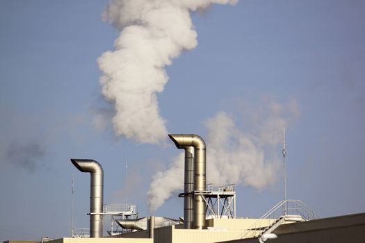 Polluting smoke leaving the chimney of a factory for a productive industry