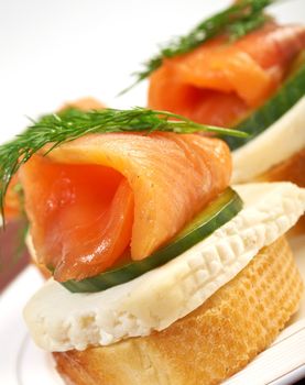    Canapes with smoked salmon,cheese and cucumber.  close up 