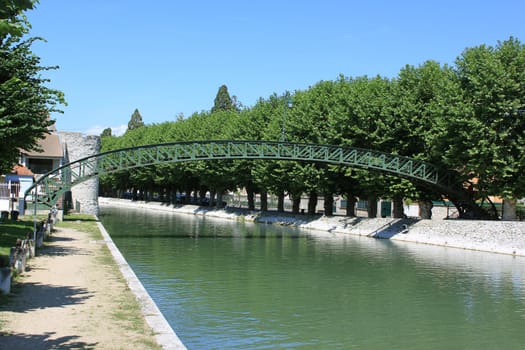 bridge rainbow sky above a river lined by trees