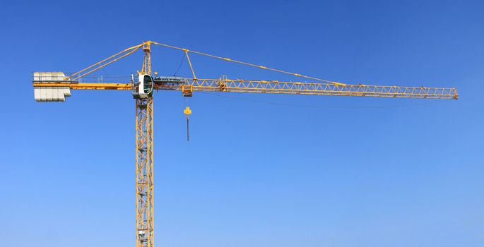 A construction crane on a blue sky background